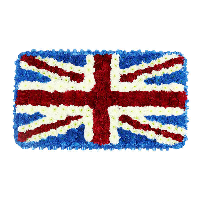 A solemn, rectangular floral arrangement interprets the Union Jack flag with exquisite precision, each line of the design built from hundreds of carefully placed blooms. The tribute lies flat against a plain white background, which throws every shade of red, white, and blue into sharp relief, allowing the floral artistry to stand on its own. Deep, inky-blue blossoms pack the corners and edge, forming a continuous border that frames the central crosses of the flag. Through this dark blue ground runs the wide red St George's Cross, the vertical and horizontal bands composed of dense, velvety red flowers, their petals tightly layered to create a bold, confident stripe. Along each side, crisp white flowers form distinct bands of fimbriation, separating the red from the surrounding blue and adding clarity to the design. From corner to corner stretch the diagonal elements: thinner red stripes for St Patrick's Cross, again carefully edged with white, resting over the broader white diagonal of St Andrew's Cross beneath. The result is a striking three-dimensional emblem, where the subtle differences in flower height and petal shape give the impression of gentle relief, as if the flag has been cushioned. The craftsmanship suggests the steady hands of a florist accustomed to creating military and state-related tributes, a familiar request for services held in churches and crematoria around Clerkenwell, St John Street, and the historic squares nearby. Though silent, the piece conveys a strong emotional message of remembrance and national identity, suited to funerals, memorial parades, or anniversaries that call for a distinctly British floral expression of respect.