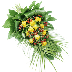 A graceful, teardrop-shaped sympathy spray is captured on a clean white background, allowing every flower and leaf to stand out with clarity. The arrangement is dominated by a generous cluster of yellow roses, their petals unfolding in varying stages from tight buds to fully open blooms. Each rose displays a rich, golden hue that suggests warmth, friendship, and enduring affection, qualities often requested by families arranging funeral flowers in Clerkenwell. Between these blooms, glossy red Hypericum berries appear in small clusters, their spherical forms and deep crimson tones weaving through the yellow roses like quiet accents of strength and remembrance. The flowers are supported by an abundance of greenery. At the upper left, where the stems are bound, large, dark green leaves overlap and, in places, are neatly folded and wrapped back, creating a sculptural foundation that anchors the design. From this focal point, the spray narrows and flows towards the lower right, where slender, palm-like fronds extend outward. Their elongated, pointed leaflets form a gentle fan that adds movement and a refined, almost modern line to the piece, echoing the blend of old and new architecture that characterises Clerkenwell. The overall composition is balanced and serene, with the yellow roses providing soft brightness and the surrounding foliage offering quiet support. This tribute would sit beautifully on a coffin, stand beside a memorial, or rest near a book of condolence, conveying a message of respect, comfort, and thoughtful farewell to someone dearly missed.