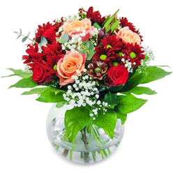 Picture gathering this luxurious bouquet in your arms as the soft London light traces through a Clerkenwell windowpane. Every crimson rose and velvety red chrysanthemum draws you in closer, their rich shades exuding depth and emotion, while the peach-tinged and apricot roses offer a gentle, glowing warmth, reminiscent of the sun rising over Farringdon Road. Sprays of gypsophila peek throughout, light as new spring blossoms spotted in Charles Square, their tiny white flowers bringing playful movement and a breath of whimsy. The shining glass vase cradles robust, freshly cut stems, magnifying their promise of life and vitality. Underneath, vibrant green foliage offers grounding structure and a subtle, verdant fragrance-a refreshing reminder of Clerkenwell's local gardens. Every blossom in this bouquet has been expertly chosen and arranged by a skilled florist, creating a beautifully balanced ensemble ideal for a festive dinner, a cherished birthday, or marking a romantic moment. The shifting array of textures-lush petals, airy gypsophila, and crisp leaves-together evoke a quiet congratulations or a brightening of the everyday, the perfect companion to life's celebrations in the heart of Clerkenwell.