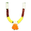 Against a clear white studio background a U-shaped ceremonial garland hangs with quiet dignity, its symmetry and colour progression immediately apparent. The top of each arm begins in a dense cuff of soft creamy-white florets - small, clustered petals that read like miniature chrysanthemums or packed carnation heads - each tuft whispering a silky, plush texture. Below the ivory, the garland gives way to a strongly textured band of deep reddish-brown elements: flattened, layered petals and petal-like shapes with a warm, earthy grain that suggests mahogany or sun-baked terracotta. As the arms curve inward the dominant band becomes a bright, cheerful golden yellow; these densely packed, pom-pom-like pieces evoke marigold (genda) blooms, their ruffled edges catching the light and lending the garland a festive, radiant energy. Where colour blocks meet, small touches of bright green appear like leaf accents or ribbon ties, breaking the transitions with a fresh, natural note. At the lowest point a voluminous pendant hangs - a multi-layered cluster of vivid orange petals, ruffled and full, forming a rounded focal tassel that anchors the U-shape and signals auspiciousness. The piece is clearly artificial - durable, cloth- or silk-like fibres tightly threaded for longevity - yet the arrangement keeps the warmth of fresh flowers: textured, tactile, and richly coloured. In a Clerkenwell home this toran would brighten a doorway for Diwali, Ganesh Chaturthi, or a wedding welcome; under soft morning light on Exmouth Market it would read as both traditional ritual and joyful domestic decor.
