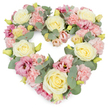 A tender, heart-shaped wreath of pastel flowers is shown against a crisp white background, its softly coloured blooms forming a complete and clearly defined heart. The arrangement is tightly packed and lush, giving the impression of a generous, carefully considered tribute created for a funeral or memorial in Clerkenwell. Creamy ivory and pale lemon roses are spaced throughout the design, their layered petals forming elegant, rounded cups that suggest purity, devotion, and lasting affection. Nestled among these roses are numerous pale pink carnations, their ruffled edges creating gentle shadows and adding a sense of depth and movement. Deeper pink and mauve lisianthus blooms offer a slightly richer note, their open, funnel-shaped petals and darker centres drawing the eye and adding emotional intensity without overpowering the soft palette. Silvery eucalyptus foliage winds between the flowers, its muted green-grey colour and rounded leaves lending a cool, calming balance and subtly reinforcing the heart's outline. Small yellow-green buds peep through the petals, indicating fresh, newly arranged flowers prepared for same-day delivery to a local chapel or crematorium. The overall feeling is one of quiet sorrow held within a frame of great tenderness, the heart symbolising a love that continues even after loss. This type of Clerkenwell funeral tribute would be chosen to honour a partner, parent, or close friend, resting beside the coffin or at a remembrance service as a gentle, floral message of sympathy, comfort, and gratitude for a life deeply valued.