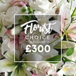 Near Exmouth Market in Clerkenwell, a lush Florist Choice Bouquet blooms with quiet confidence, its pure white roses and white lilies standing tall among soft pink-tinted inner petals and small blush blooms. The arrangement is framed by gentle green foliage-eucalyptus-like leaves that add texture and a fresh, garden-clean scent. The bouquet fills the frame with a generous, hand-tied volume, each stem placed for rhythm and balance, as if the florist had sketched a living sculpture. A white rectangular overlay sits in the center with a slim border, carrying the product label in elegant type: 'Florist' in a flowing script, 'CHOICE BOUQUET' in bold uppercase sans-serif, and below it '? BOUQUET ?' with the price '?300' in large white numerals. The overall feel is premium, refined, and ready to gift for anniversaries, significant birthdays, or moments of sympathy that deserve a tender gesture. The soft morning light bathes the petals in a pearly sheen, making the whites feel luminous and the pink accents glow gently. This image reads as a promise of freshness and care from a local florist who knows this community from Clerkenwell Green to Leather Lane Market, and Clerkenwell Flowers delivers same-day across the area to homes and businesses. The scent lingers as a subtle invitation, and the bouquet's generous form makes it suitable for a dining table centerpiece or a hospital visit gift.