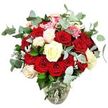 An extravagant rose bouquet is shown in meticulous detail, resting in a clear glass vase against a flawless white backdrop, much like a display you might find in a boutique along Clerkenwell Road. The vase itself has a rounded, gently bulbous base that narrows at the neck, securely holding a bundle of green stems immersed in clean water, their lines criss-crossing in a tidy, organic pattern. Rising from this base, the arrangement forms a rich, rounded mound of flowers and foliage, densely packed so that petals almost touch from one side to the other. Dominant throughout are deep red and bold scarlet roses, some in tight buds full of promise, others fully opened, their velvety petals layered in spirals which speak of intense romance and heartfelt emotion. Weaving between these passionate tones are white and creamy ivory roses, their gentler shades adding light and a feeling of calm, with a few petals brushed softly with pale pink at the edges to introduce a note of sweetness. Small clusters of vivid pink filler flowers, resembling dainty mini carnations or berry-like blooms, punctuate the bouquet with playful highlights and fine-grained texture. Surrounding the roses, generous sprays of blue-green eucalyptus arch outward, their rounded, slightly frosted leaves suggesting a cool, refreshing fragrance. Additional dark green foliage and subtle silvery-green leaves nestle around the blooms, giving the bouquet volume and a natural, garden-inspired structure. The stark white background allows every colour and detail to stand out clearly, creating an impression of classic elegance and modern style, perfect for a romantic surprise in Clerkenwell-whether sent to an office near Old Street or a cosy flat tucked behind Charterhouse Square.