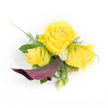 A small, wearable bouquet arranged with the attention of a careful florist: three sunny yellow roses form the heart of this corsage, the central bloom fully open and two slightly smaller roses gently cupped beside it. Each rose cradles a tiny clear rhinestone at its centre, a glassy pinprick of sparkle that catches the light like early morning dew on Exmouth Market stalls. Beneath the trio, a single deep plum calla lily unfurls in a sculptural curve, its velvety throat turning downward and to the left to provide dramatic contrast against the luminous yellow. Around these focal flowers, airy asparagus fern fronds breathe softness into the design while broader dark-green leaves create a solid, structured backdrop; small, white button chrysanthemums nestle between petals to lift the composition and add a whisper of cream. Two rounded green buds peek from the lower right, promising growth and natural rhythm, and a faint, lacy strip of white organza or feathered trim behind the left-most rose offers a delicate, bridal suggestion without obscuring the blooms.
The texture is tactile in the mind: buttery rose petals, the satiny calla curve, the tickle of feathery greens, and the cool gleam of crystal accents. The scent would be a gentle rose perfume, tempered by green, herbaceous notes-an elegant accent suitable for a wedding, prom, or celebratory event in Clerkenwell or nearby Farringdon. A local florist would tuck this onto a lapel or wrist with care, mindful of movement and light so the jewels and blooms shine in candid street-side photographs or soft chapel lighting.