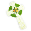 A three-dimensional Celtic cross of fresh flowers captured against a crisp white backdrop, seen from a gentle overhead angle that reveals its plush texture and sculpted form. The arms and elongated lower shaft are densely built from pure white spray chrysanthemums, their tiny faces packed closely to create a soft, cloud-like surface that reads of quiet dignity and purity. Interwoven through that white field are vivid apple-green button chrysanthemums, placed with geometric intent to trace the circular ring at the cross's centre and to mark alternating segments along the horizontal arms; these lime-green cushions lend tactile contrast and a contemporary vibrancy to the traditional symbol. At the heart where the arms meet, three fully opened orange roses-warm, golden-amber in tone-sit as a small, luminous focal grouping, their layered petals catching the light and sending a subtle glow across the surrounding whites and greens. A few dark green fern fronds nestle the roses, their slender, serrated leaves framing the blooms and deepening the composition with cool, botanical accents. The lighting is soft and even, revealing the satin sheen of rose petals and the matte, feathery texture of the chrysanthemums, while the white background isolates the cross so every detail reads clearly. As a florist who has arranged memorial tributes for families across Clerkenwell and near Exmouth Market, I sense this piece carries both reverence and quiet warmth-its palette echoing the Irish flag and serving as a respectful funeral or remembrance tribute for someone with Celtic roots. The overall effect is one of careful craftsmanship: restrained, heartfelt, and elegantly rooted in tradition.